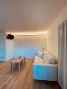 een woonkamer met een bank en een tafel bij Tellure apartments with breakfast in Berbenno di Valtellina