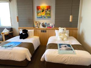 two beds with stuffed teddy bears sitting on them at Kowakuen Haruka in Matsuyama