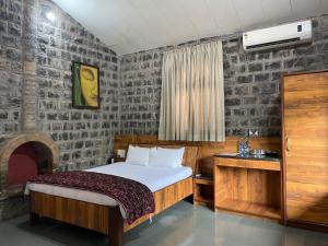 a bedroom with a bed and a desk and a bed sidx sidx sidx at The Green Gate Resort Mulshi in Pune
