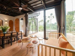 ein Wohnzimmer mit einem Tisch und einigen Stühlen in der Unterkunft Villa de Montana in Ba Vì