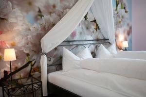 a bedroom with a canopy bed with flowers on the wall at Gasthof Löwen Herznach in Herznach