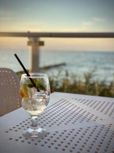 a glass of water sitting on a table near the ocean at AHOY - Haus am Meer in Chłopy