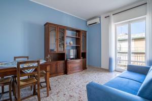 a living room with a table and a blue wall at Casa Sofocle Comodo bivani a Siracusa posto nell'antico quartiere della Borgata in Syracuse