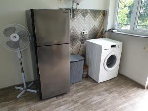 a kitchen with a refrigerator and a washing machine at Green paradise in Batumi