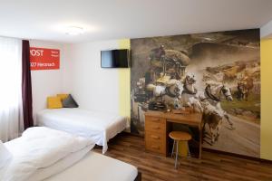 Cette chambre comprend deux lits et un tableau mural. dans l'établissement Gasthof Löwen Herznach, à Herznach