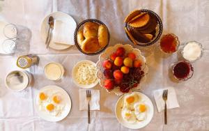 a table with plates of food and a bowl of fruit at Karakol Yurt Village in Karakol