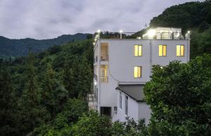 - un bâtiment blanc avec des lumières au sommet d'une colline dans l'établissement Limonchelo, à Kobuleti
