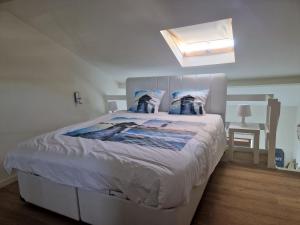 a bedroom with a large bed with a white headboard at Melroce Holiday Cottage 5503 in Bredene