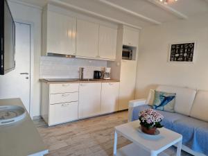 a kitchen and a living room with a couch and a table at Melroce Holiday Cottage 5503 in Bredene