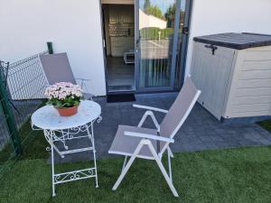a patio with a table and two chairs and a table with flowers at Melroce Holiday Cottage 5503 in Bredene
