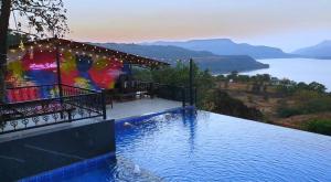 una piscina con vistas al agua en The Green Gate Resort Mulshi, en Pune