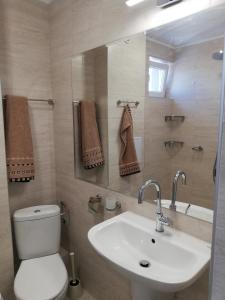 a bathroom with a white toilet and a sink at Hotel GAIA in Sozopol