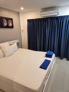 a bedroom with a large bed with blue towels on it at Galaxy Suites in Pattaya South