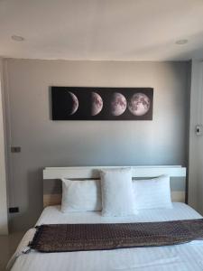 a bedroom with a bed with three moons on the wall at Galaxy Suites in Pattaya South