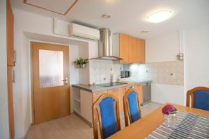 uma cozinha com uma mesa e cadeiras azuis em Apartma Bajc em Ajdovščina