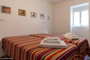 ein Schlafzimmer mit 2 Betten und Handtüchern darauf in der Unterkunft Casas da Baronia in Vila Nova da Baronia