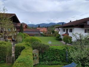 uma vista para um pátio com sebes e uma casa em Ferienwohnung Achental em Marquartstein