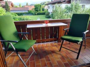 2 sillas y una mesa en el balcón en Ferienwohnung Achental en Marquartstein