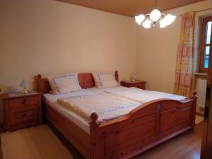 ein Schlafzimmer mit einem großen Holzbett mit zwei Nachttischen in der Unterkunft Ferienwohnung Achental in Marquartstein