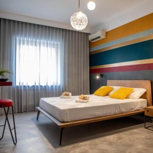 ein Schlafzimmer mit einem großen Bett mit gelben und blauen Streifen in der Unterkunft B&B Colore Verace in Pompei