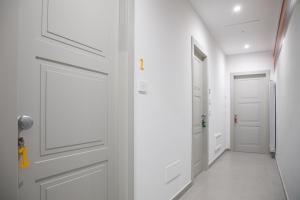 einen Flur mit einer weißen Tür mit einem Bild darauf in der Unterkunft B&B Colore Verace in Pompei