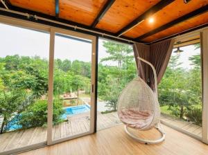 eine Hängematte auf einer Veranda mit Poolblick in der Unterkunft Villa de Montana in Ba Vì