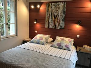 a bedroom with a bed with two pillows at La tanière des ours in Chaumont-sur-Tharonne