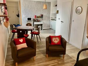 un soggiorno con 2 sedie e un tavolo di Gite Saint Florent Studio Apartment Parking Gratuit a Strasburgo