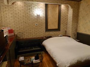 um quarto com uma cama e um sofá em スタイリッシュ栃木　大人専用 em Shimotsuke