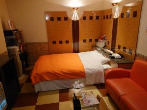 une chambre d'hôtel avec un lit et un canapé dans l'établissement スタイリッシュ栃木　大人専用, à Shimotsuke