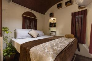 a bedroom with a large bed and a window at Munkudil Ayurveda & Yoga Retreat in Kuttampuzha