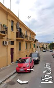 a red car parked in a parking lot next to a building at Casa Vacanze Bei Ricordi in Reggio Calabria