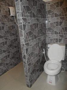 a bathroom with a toilet with a stone wall at Life&Love Resort in Ban Khlong Son
