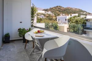 uma mesa e cadeiras numa varanda com vista em Plakias Family Apartment em Plakiás