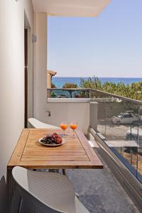 un tavolo con 2 bicchieri di succo d'arancia su un balcone di Plakias Family Apartment a Plakiás