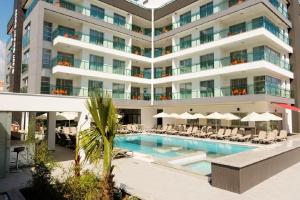 un hotel con piscina frente a un edificio en Green Garden Suites Hotel, en Alanya