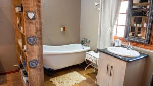 bagno con vasca e lavandino di Four Seasons Guesthouses a Lephalale