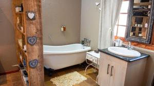 a bathroom with a bath tub and a sink at Four Seasons Guesthouses in Lephalale