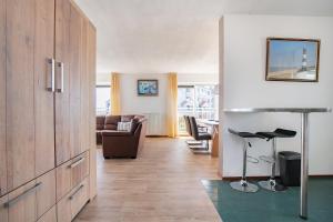 a living room with a large wooden cabinet and a couch at Hello Zeeland - Appartement Port Scaldis 15-042 in Breskens