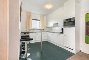 uma cozinha branca com armários brancos e um balcão em Hello Zeeland - Appartement Port Scaldis 15-042 em Breskens