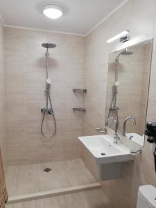 a bathroom with a shower and a white sink at Hotel GAIA in Sozopol