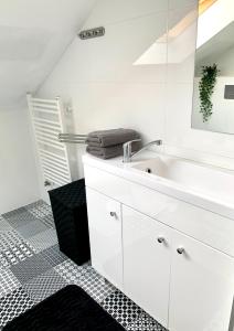 a white bathroom with a sink and a mirror at AHOY - Haus am Meer in Chłopy