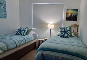 a small bedroom with two beds and a lamp at CHILL-OUT LAKESIDE - Wallis Lake Forster in Forster +24 photos