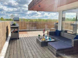 a patio with a couch and a grill on a deck at Skyhouse Riga Lux Penthouse & SPA in Rīga
