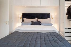 a bedroom with a large bed with a black headboard at Stadsporten Nacka in Nacka +38 photos