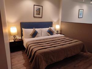 فندق كازا دور في بيروت: غرفة نوم بسرير كبير فيها مصباحين