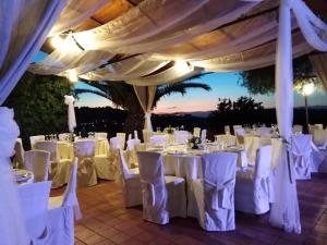 カルレンティーニにあるBorgo Nocchiaraの白いテーブルと椅子が備わる結婚式のレセプションのセットアップ