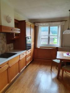 a kitchen with wooden cabinets and a table and a window at Ferienhaus Waldglück in Gosau