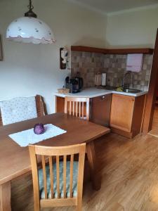 een keuken met een houten tafel en een tafel en stoelen bij Ferienhaus Waldglück in Gosau