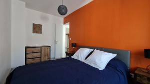 1 dormitorio con 1 cama azul y pared de color naranja en Cahors, the place to be ! :), en Cahors